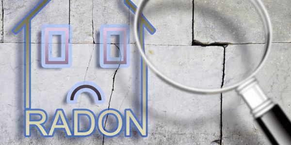 The danger of radon gas in our homes - concept image with an outline of a small house with radon text against a cracked stone wall with a magnifying glass